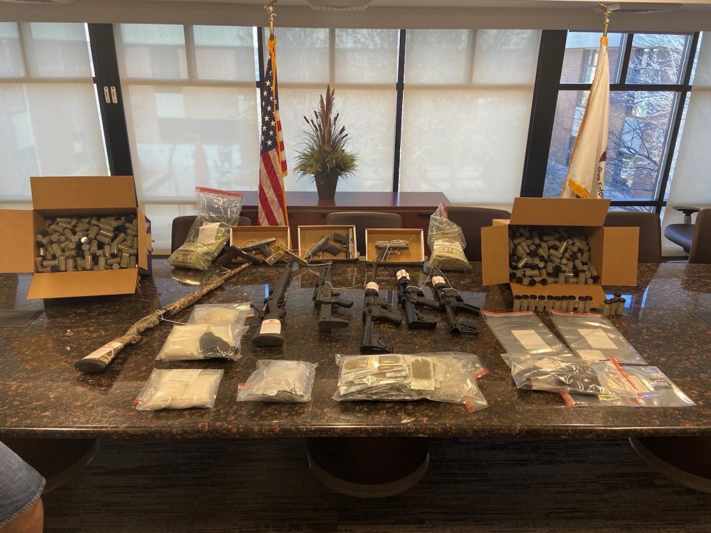 a photo of guns, cash, and bath salts that were recovered during an investigation