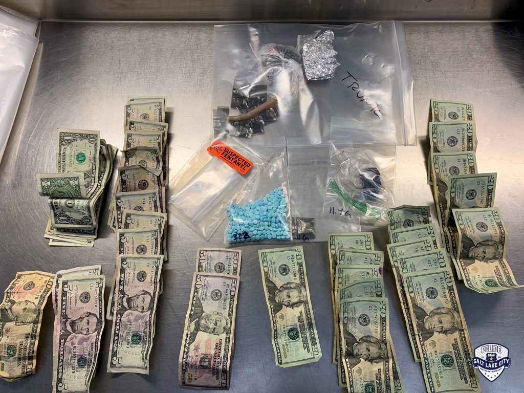 A photo of recently seized M30 pills, cash, and drug paraphernalia.